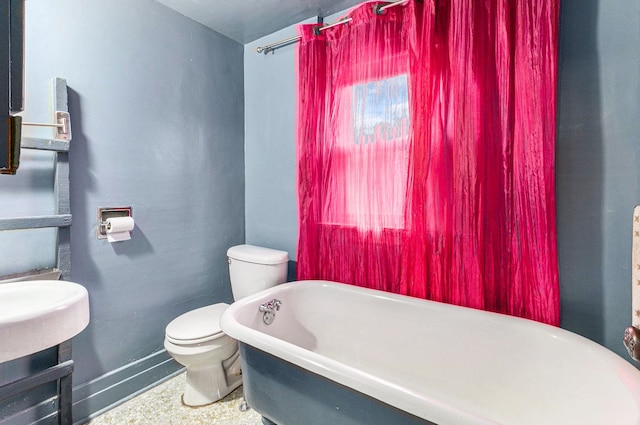 full bath featuring toilet and a freestanding tub