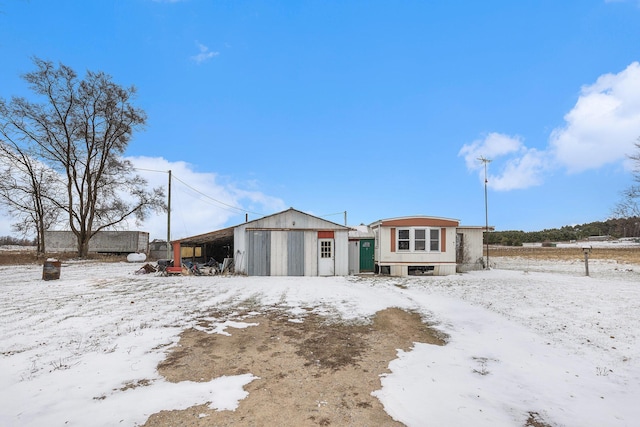 snow covered property featuring an outdoor structure