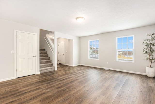 unfurnished living room with dark hardwood / wood-style flooring