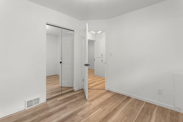 unfurnished bedroom featuring light hardwood / wood-style floors and a closet