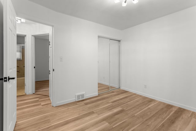 unfurnished bedroom with a closet and light hardwood / wood-style flooring