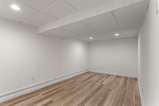 spare room with hardwood / wood-style floors and a drop ceiling