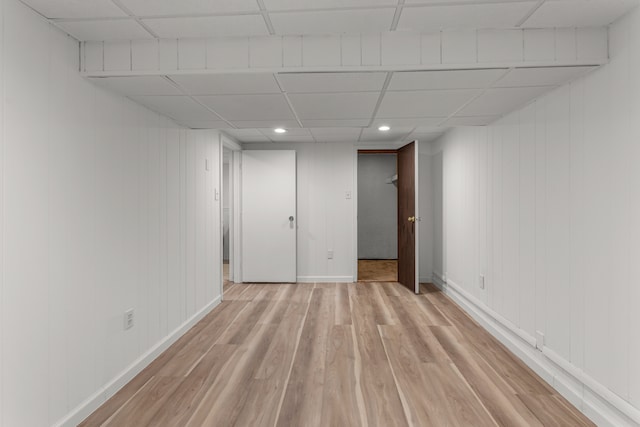 empty room featuring light wood-type flooring and a drop ceiling