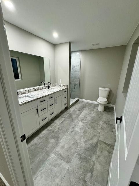 bathroom with a shower, vanity, and toilet