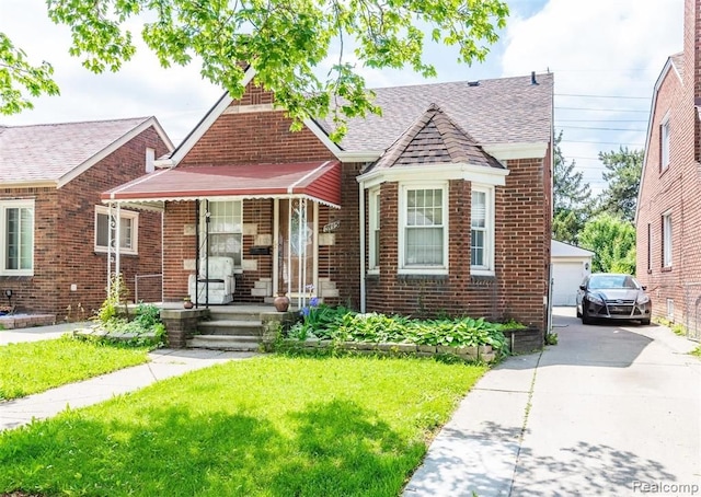 bungalow with an outdoor structure, a front yard, and a garage