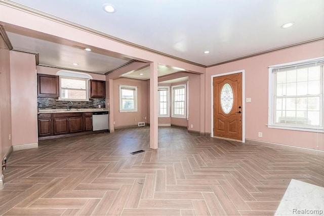 entrance foyer with sink, light parquet flooring, and ornamental molding