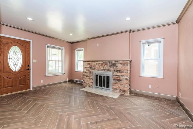 unfurnished living room featuring ornamental molding, a fireplace, and parquet floors