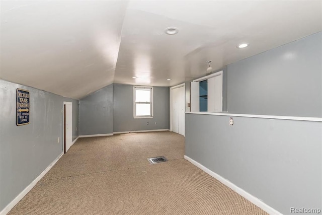 additional living space with carpet flooring and vaulted ceiling