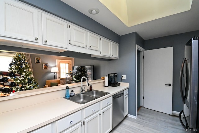 kitchen featuring white cabinets, stainless steel appliances, a wealth of natural light, and sink