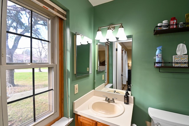 bathroom featuring vanity, a healthy amount of sunlight, and toilet