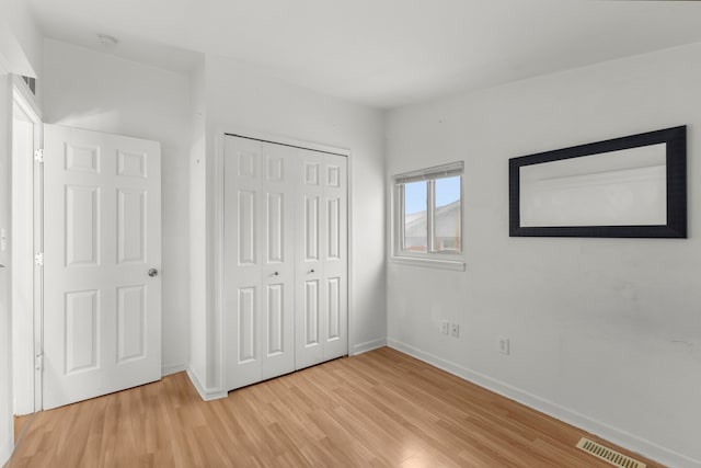 unfurnished bedroom featuring a closet and light wood-type flooring