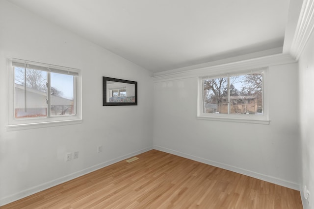 unfurnished room featuring light hardwood / wood-style floors, plenty of natural light, and lofted ceiling