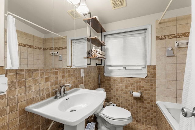 full bathroom with shower / bath combo, toilet, tile walls, and sink