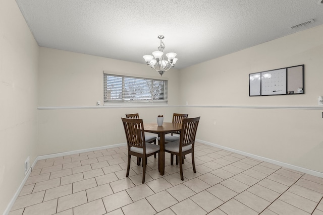 dining area with a notable chandelier and a textured ceiling