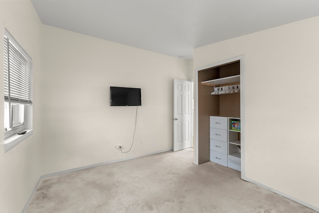 unfurnished bedroom with light carpet and a closet