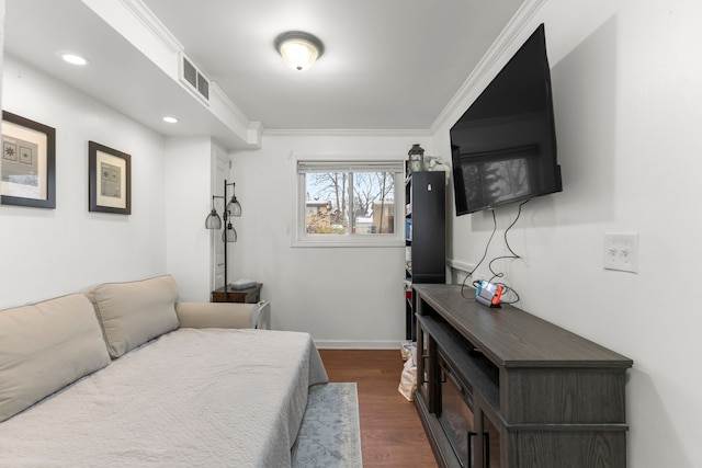 bedroom with dark hardwood / wood-style floors and ornamental molding