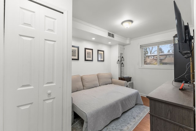 bedroom featuring wood-type flooring and ornamental molding