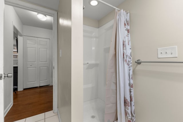 bathroom featuring curtained shower and wood-type flooring