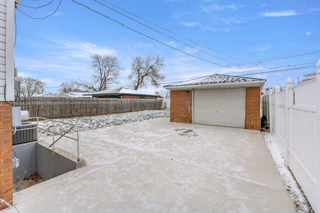 snow covered garage with central air condition unit