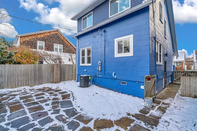 snow covered property featuring central air condition unit