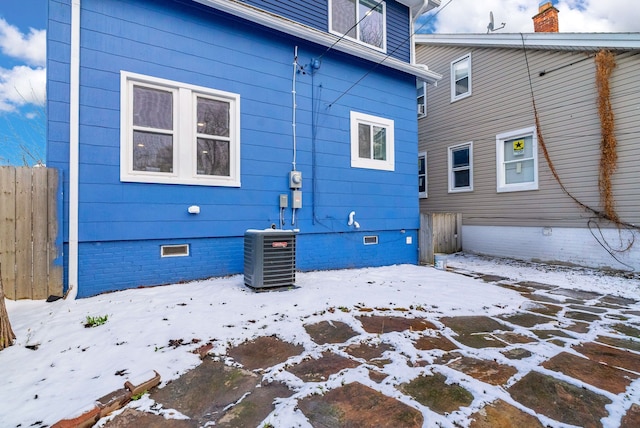 snow covered house with central air condition unit