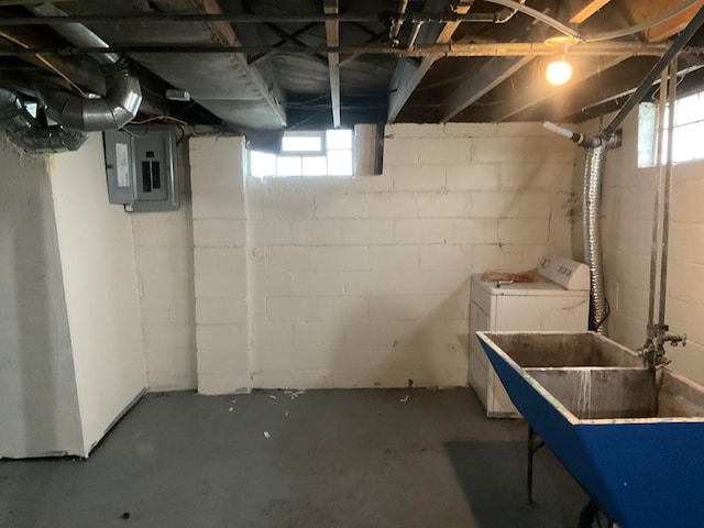 basement with sink, electric panel, and washing machine and clothes dryer