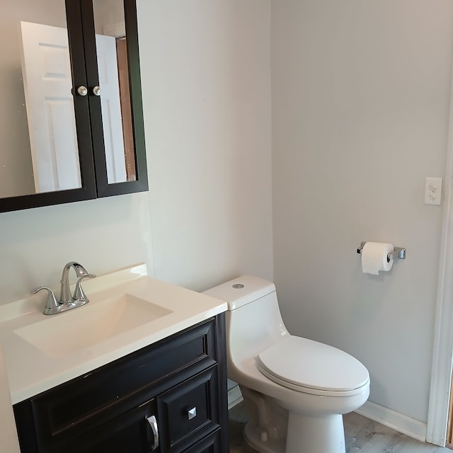 bathroom featuring hardwood / wood-style floors, vanity, and toilet