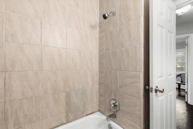 bathroom with tiled shower / bath combo and hardwood / wood-style flooring