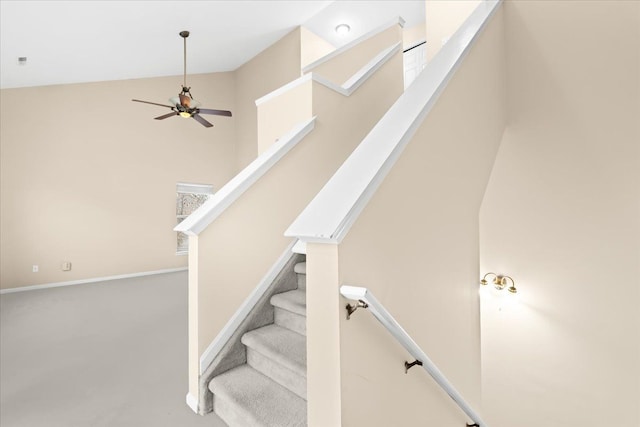 staircase featuring ceiling fan and lofted ceiling