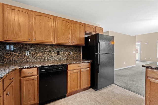 kitchen with dark stone counters, backsplash, light colored carpet, and black appliances