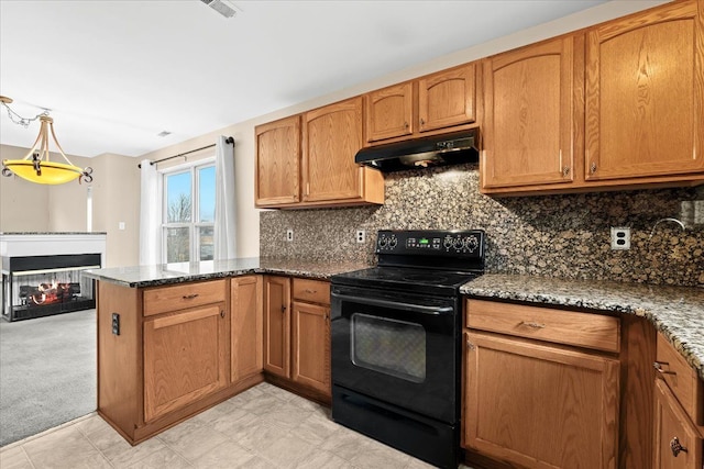 kitchen with kitchen peninsula, backsplash, dark stone counters, a multi sided fireplace, and black electric range oven