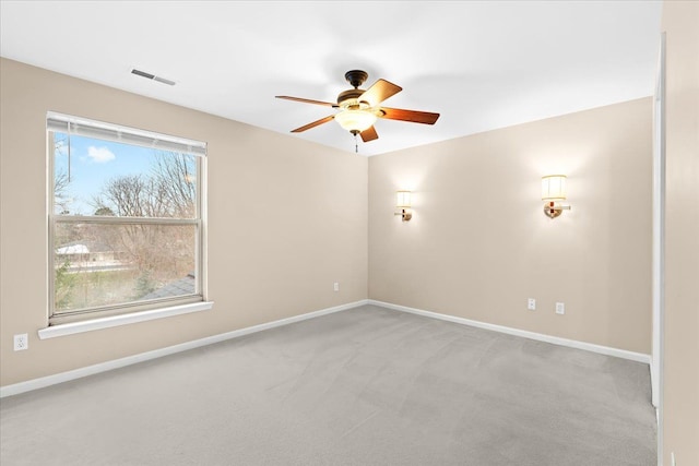 spare room with ceiling fan and light colored carpet