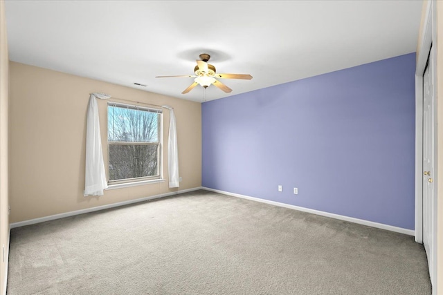 spare room featuring ceiling fan and carpet floors