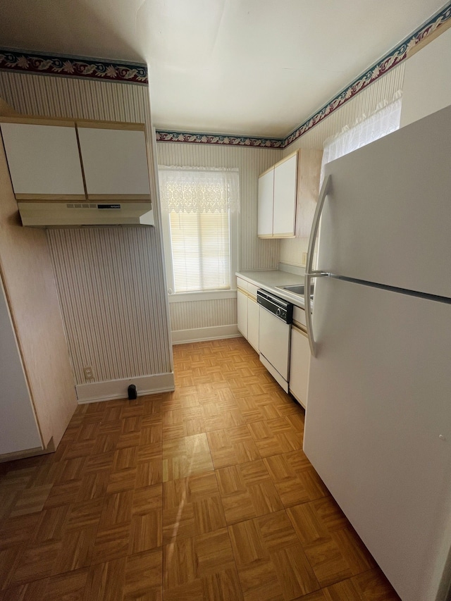 kitchen featuring light parquet flooring, white cabinets, and white appliances