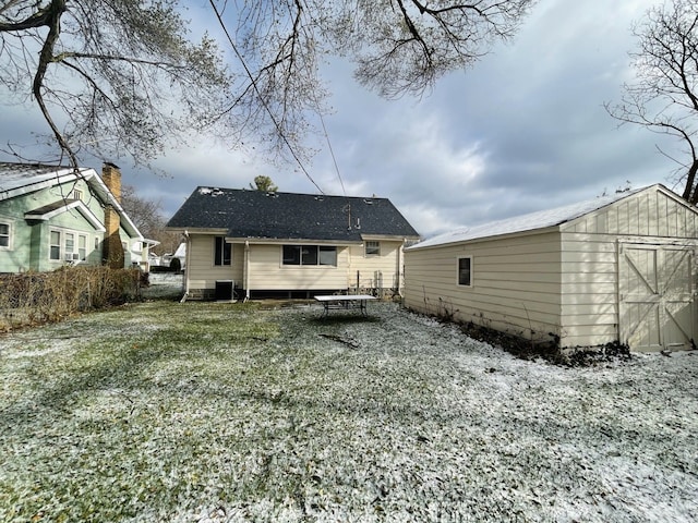 back of house featuring a storage shed and a lawn