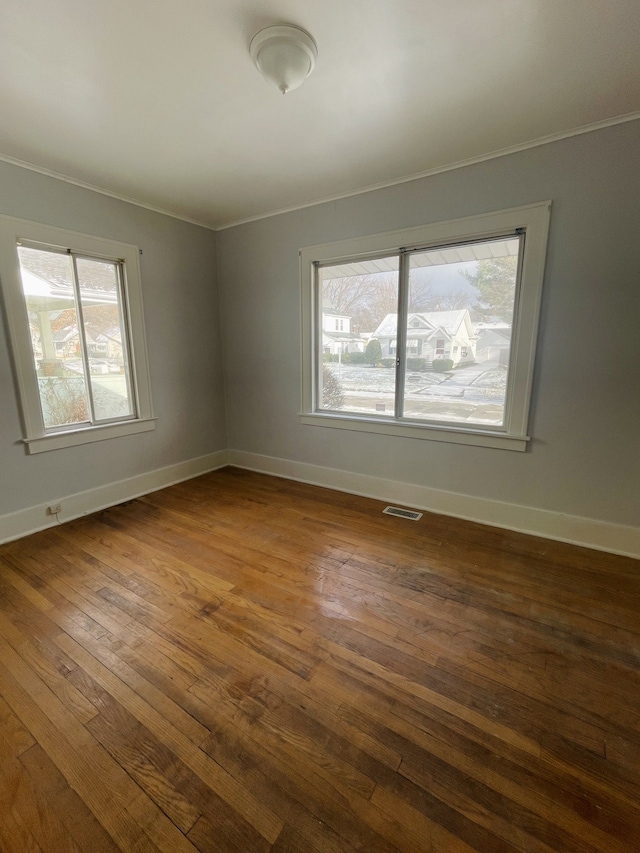 unfurnished room featuring dark hardwood / wood-style floors and crown molding