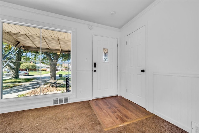 entryway with carpet flooring and crown molding