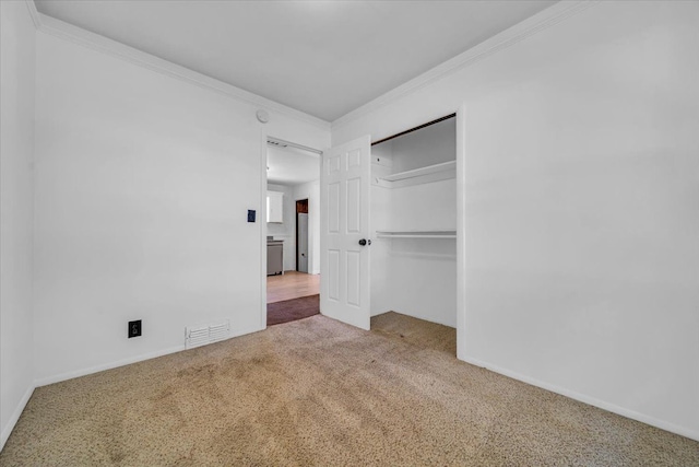 unfurnished bedroom with a closet, carpet floors, and ornamental molding