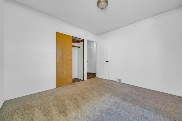 unfurnished bedroom with carpet flooring, a closet, and crown molding