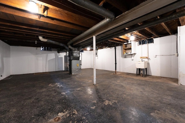 basement with sink, heating unit, and water heater