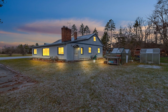 back house at dusk with an outbuilding