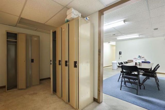 corridor with a drop ceiling and light carpet