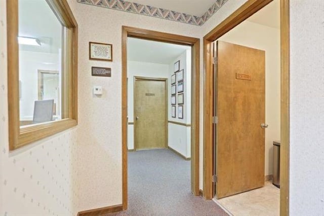 corridor featuring light colored carpet