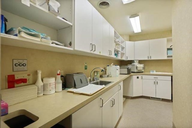 kitchen featuring sink and white cabinets