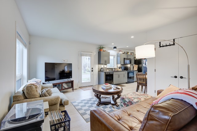 living room with beverage cooler and light hardwood / wood-style flooring