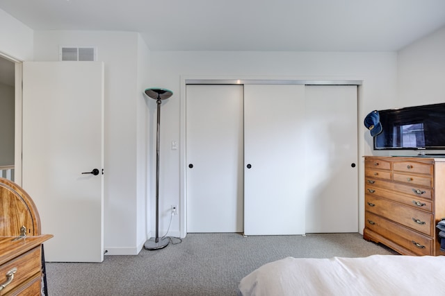 bedroom with light carpet and a closet