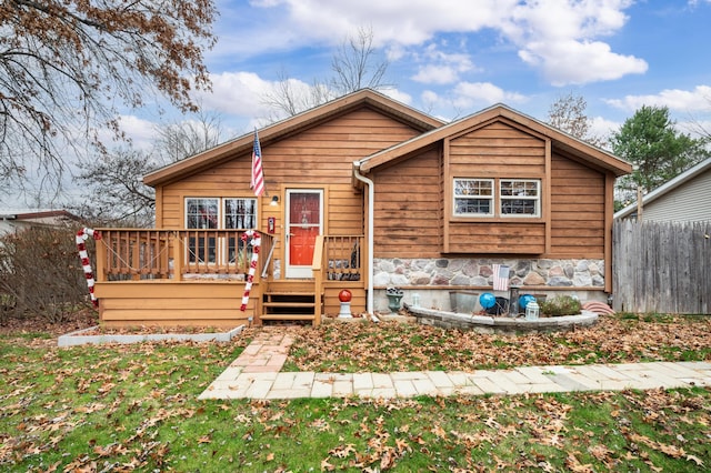 view of front of property featuring a front yard and a deck