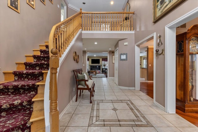 entryway with a towering ceiling and light tile patterned flooring