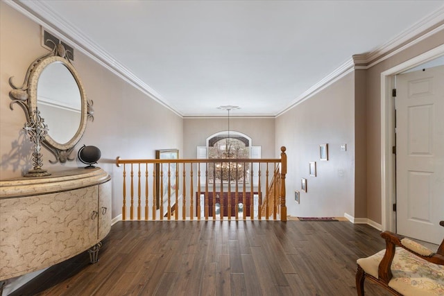 hallway with dark hardwood / wood-style floors, an inviting chandelier, and crown molding