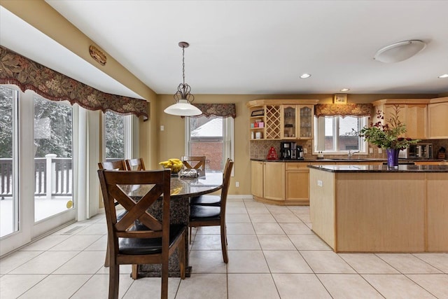 kitchen featuring light tile patterned floors, light brown cabinets, and decorative light fixtures